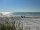 Beautiful beach view with crystal-clear waters, soft sand, and calm waves on the horizon at 1500 Gulf Blvd # 103B, Indian Rocks Beach, FL 33785