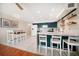 Open kitchen featuring bar seating, white appliances, teal cabinets and floating shelves at 1500 Gulf Blvd # 103B, Indian Rocks Beach, FL 33785