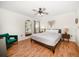 Comfortable main bedroom featuring a ceiling fan, warm laminate flooring, and neutral decor at 1500 Gulf Blvd # 103B, Indian Rocks Beach, FL 33785