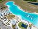 Aerial view showcases the lagoon's clear water, beach area, and recreational water inflatables at 16810 Trite Bend St, Wimauma, FL 33598