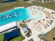 Aerial view of the lagoon featuring a water park, beach, cabanas, lounge seating, and other community amenities at 16810 Trite Bend St, Wimauma, FL 33598