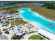 Aerial view of the community lagoon, showcasing the beach area, turquoise water, and outdoor recreation spaces at 16810 Trite Bend St, Wimauma, FL 33598