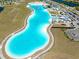 Aerial view of a community lagoon with recreation, parking, and surrounding development at 16810 Trite Bend St, Wimauma, FL 33598