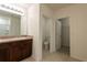 Bathroom with double sink vanity, tiled floors, and toilet with walk in closet at 16810 Trite Bend St, Wimauma, FL 33598