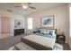 A nicely decorated bedroom with a neutral color scheme and large artwork at 16810 Trite Bend St, Wimauma, FL 33598
