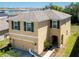 Inviting two-story home featuring a covered porch, a two-car garage, and lush landscaping at 16810 Trite Bend St, Wimauma, FL 33598