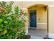 Welcoming front porch with lush greenery and vibrant flowers, leading to a stylish entrance at 16810 Trite Bend St, Wimauma, FL 33598