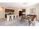 An open-concept kitchen and dining area is decorated with neutral colors and a modern chandelier at 16810 Trite Bend St, Wimauma, FL 33598