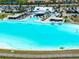 Aerial view of aqua lagoon featuring a swim up bar, sandy beach, and community center at 16810 Trite Bend St, Wimauma, FL 33598