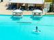 Aerial view of aqua lagoon featuring cabana lounge areas, sandy beach, and crystal clear water at 16810 Trite Bend St, Wimauma, FL 33598