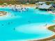 An aerial view of the community lagoon featuring an inflatable water park and beach-like amenities at 16810 Trite Bend St, Wimauma, FL 33598