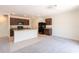 Modern kitchen and living area with dark cabinets, granite counters, and an open layout at 16810 Trite Bend St, Wimauma, FL 33598