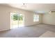 Bright living room with sliding glass doors to the backyard, carpet flooring, and neutral walls at 16810 Trite Bend St, Wimauma, FL 33598