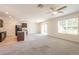 Open-concept living space with a modern kitchen and an adjacent living area with sliding glass doors to the backyard at 16810 Trite Bend St, Wimauma, FL 33598