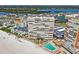 Aerial view of beachfront condos featuring a swimming pool, lounge area, and pristine white sand beach at 17940 Gulf Blvd # 9B, Redington Shores, FL 33708