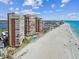 High-rise condo buildings on white sands with beachgoers, a community pool and bright blue skies at 17940 Gulf Blvd # 9B, Redington Shores, FL 33708