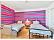 Fun bedroom featuring two beds and a colorful striped accent wall at 17940 Gulf Blvd # 9B, Redington Shores, FL 33708