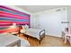 Bright bedroom featuring colorful striped wall and two beds with patterned bedding at 17940 Gulf Blvd # 9B, Redington Shores, FL 33708