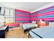 Bedroom featuring two beds with a colorful striped wall and shuttered window at 17940 Gulf Blvd # 9B, Redington Shores, FL 33708