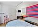 Bedroom with colorful striped wall, hardwood floors, and twin beds, plus a pink vanity at 17940 Gulf Blvd # 9B, Redington Shores, FL 33708