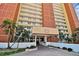 Condo building entrance featuring a covered walkway, palm trees, and well-maintained landscaping at 17940 Gulf Blvd # 9B, Redington Shores, FL 33708