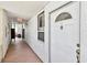 Exterior white door with transom window and door knocker with long hallway view at 17940 Gulf Blvd # 9B, Redington Shores, FL 33708