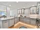 Contemporary kitchen with gray cabinets, stainless steel appliances, and unique herringbone flooring at 17940 Gulf Blvd # 9B, Redington Shores, FL 33708