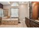 Elegant bathroom featuring a soaking tub, a separate shower, and dark wood cabinets with granite countertops at 18533 Avocet Dr, Lutz, FL 33558
