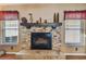 Cozy stone fireplace with decorative mantel and accents, flanked by bright windows with red valances at 18533 Avocet Dr, Lutz, FL 33558