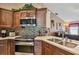 Close-up of kitchen features stainless steel appliances, granite countertops, tile backsplash, and wooden cabinets at 18533 Avocet Dr, Lutz, FL 33558