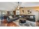 Open-concept living room with a large leather sectional sofa, rug, and view into the kitchen at 18533 Avocet Dr, Lutz, FL 33558