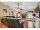Spacious living room with fireplace, large leather sofa, ceiling fan, and hardwood floors at 18533 Avocet Dr, Lutz, FL 33558