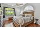 Bedroom with neutral decor, hardwood floors, large window, and a ceiling fan at 18533 Avocet Dr, Lutz, FL 33558