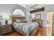 Comfortable bedroom boasts warm wood floors, a ceiling fan, and stylish decor, creating a cozy and inviting atmosphere at 18533 Avocet Dr, Lutz, FL 33558
