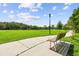 Peaceful park view with a sidewalk, park bench, and green grassy field at 18533 Avocet Dr, Lutz, FL 33558