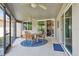 Screened patio with ceiling fans, sliding glass doors, and a round wooden table with chairs at 18533 Avocet Dr, Lutz, FL 33558