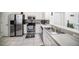 Well-lit kitchen featuring stainless steel appliances, white cabinets, and modern tile backsplash at 18981 Duquesne Dr, Tampa, FL 33647