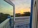 Picturesque waterfront sunset view through a balcony doorway with decorative railings and blue accents at 228 Shore Dr, Tarpon Springs, FL 34689