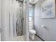 Bathroom featuring a tiled walk-in shower, toilet, and window with view, along with beach themed decor at 228 Shore Dr, Tarpon Springs, FL 34689
