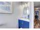 Powder room featuring a vanity with blue cabinets and a modern framed mirror, with hardwood floors at 228 Shore Dr, Tarpon Springs, FL 34689