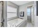 Bright bathroom featuring a soaking tub with tile surround, towels, and a view from a window at 228 Shore Dr, Tarpon Springs, FL 34689