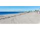 Expansive white sand beach with gentle waves, seagrass, and peaceful views of the water at 228 Shore Dr, Tarpon Springs, FL 34689