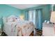 Bright bedroom with a queen bed featuring tropical flamingo themed bedding, and curtains filtering soft natural light at 228 Shore Dr, Tarpon Springs, FL 34689