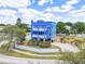 Stunning blue two-story home with beautiful landscaping and a white fence at 228 Shore Dr, Tarpon Springs, FL 34689