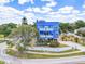 Striking blue three-story home featuring white balconies and lush landscaping at 228 Shore Dr, Tarpon Springs, FL 34689