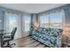 Living area with a sofa, desk, and large windows with ocean views, with an ocean themed aesthetic at 228 Shore Dr, Tarpon Springs, FL 34689