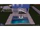 A modern in-ground pool with a sun shelf and seating set in a gray tiled yard at 228 Shore Dr, Tarpon Springs, FL 34689