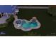 A beautiful in-ground pool with gray trim and an umbrella, set in a green yard at 228 Shore Dr, Tarpon Springs, FL 34689