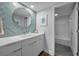 Beautiful bathroom with a modern vanity, round mirror, and tiled accent wall at 240 Sand Key Estates Dr # 58, Clearwater Beach, FL 33767