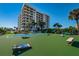 View of community area, with shuffleboard and cornhole boards with towering building in background at 240 Sand Key Estates Dr # 58, Clearwater Beach, FL 33767